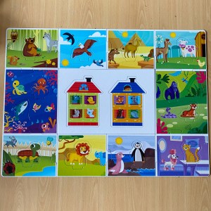 A small jigsaw style playmat is laid on light brown laminate flooring. Each piece of the play mat has a different scene with various animals in and each piece has various bright colours. 
