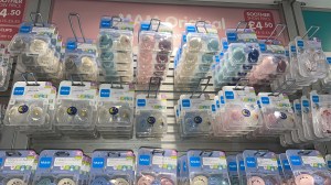 Photo of various MAM soothers and dummy clips on their stand.